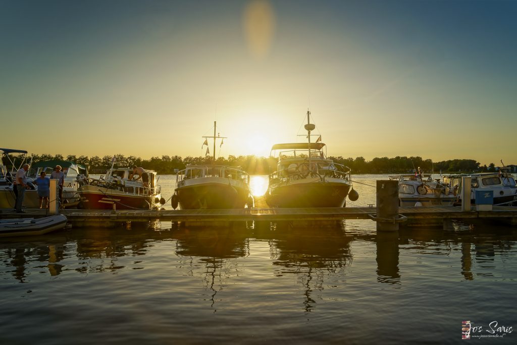 boats on a dock with a sunset in the background