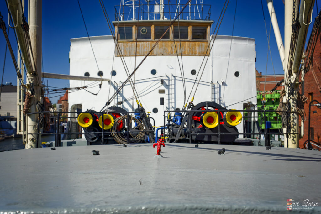 a red fire hydrant on a deck of a ship