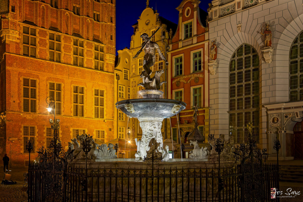 a statue of a man holding a spear in a fountain