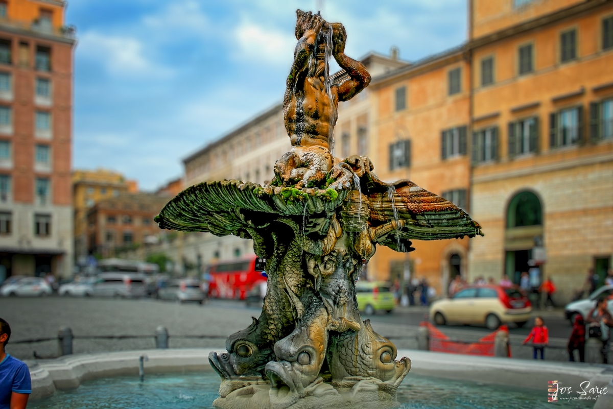 a statue of a man holding a shell in front of a building
