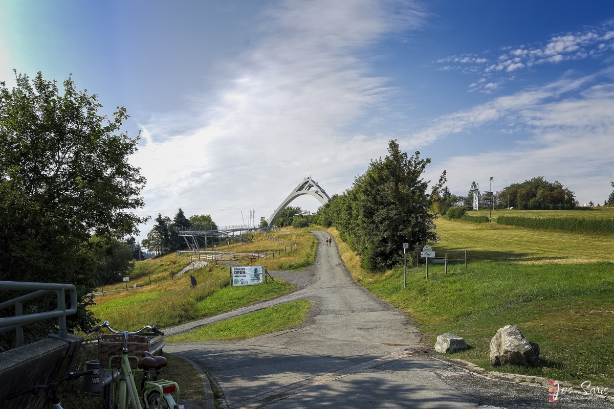 a path with a white arch in the distance