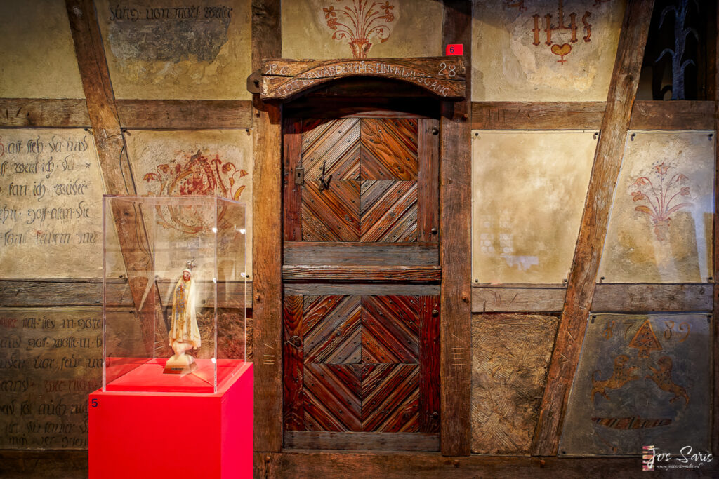 a wooden door with a glass case in front of it