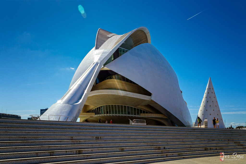 a white building with a curved roof with Sydney Opera House in the background